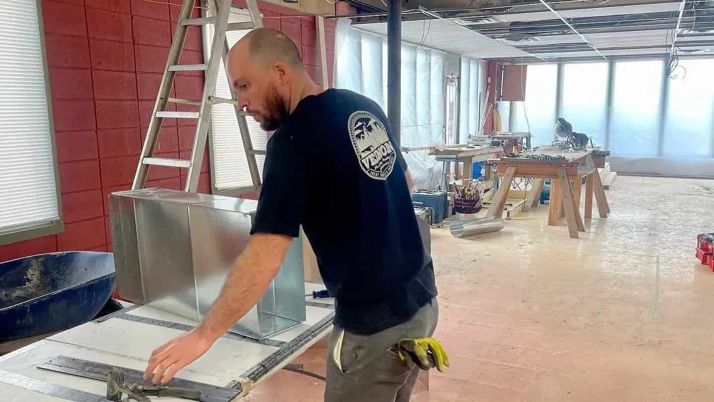 HVAC tech working on upgrading ducting for AI zoning
