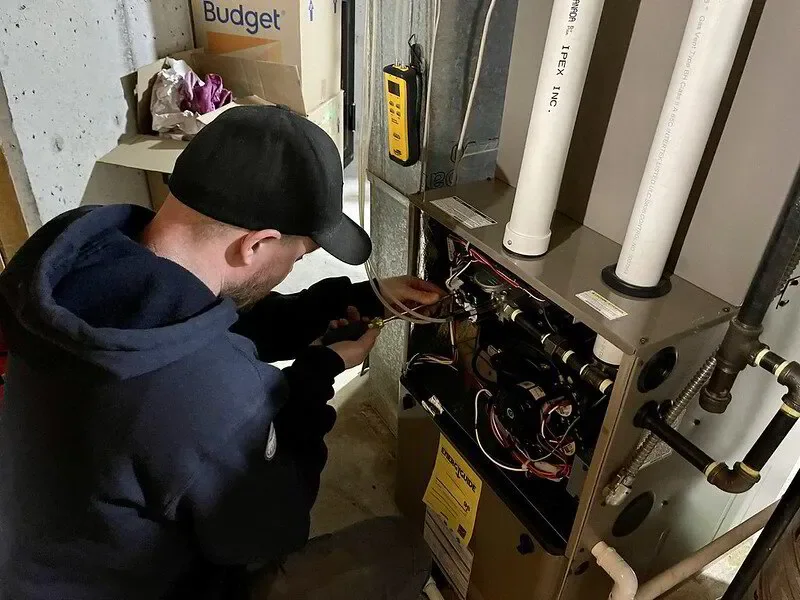 HVAC technician working on a central ducted heat pump system