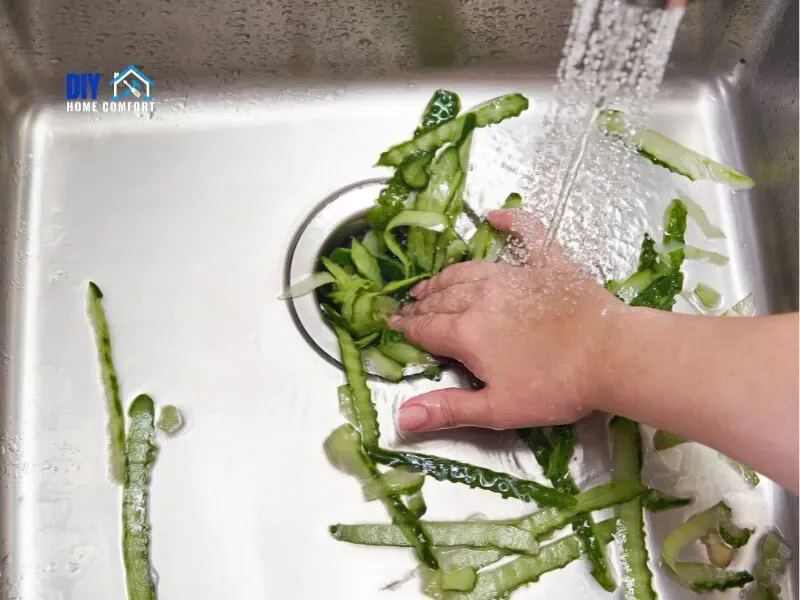 feeding food scraps into garbage disposal