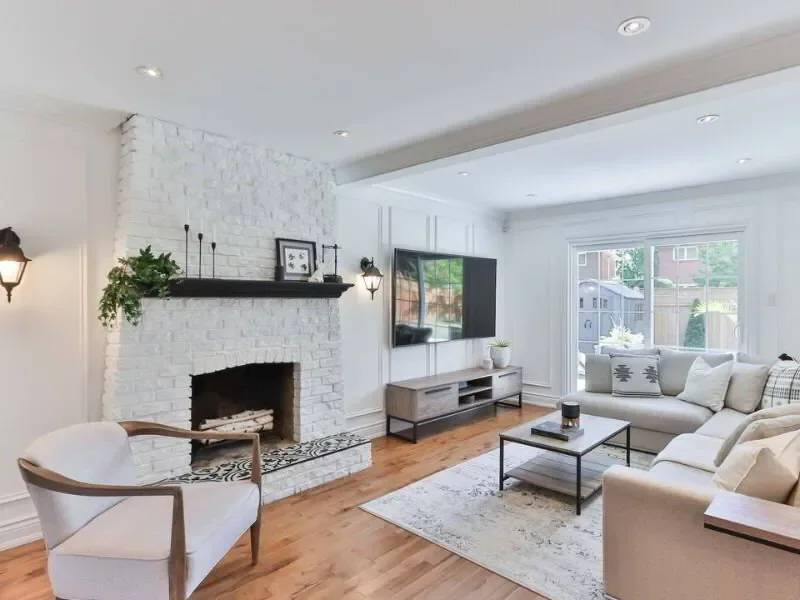 living room with exposed brick fireplace